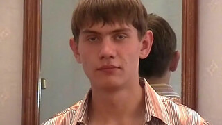 Парень гей устроившись на кровати  ласкает свой большой член