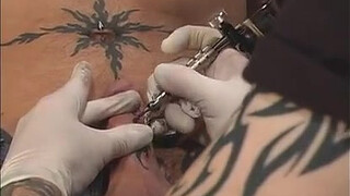 Делает татуировку на члене мужика